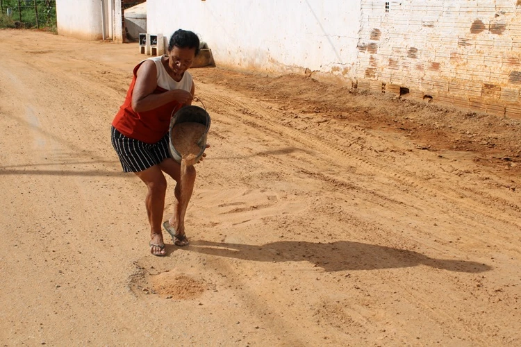 Brumado: Idosa tapa buracos com baldes de areia um ano após governador prometer asfalto