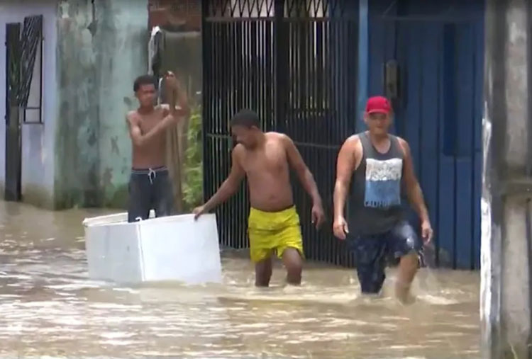 Morador usa geladeira para conseguir visitar casa alagada após enchente em Ubaitaba