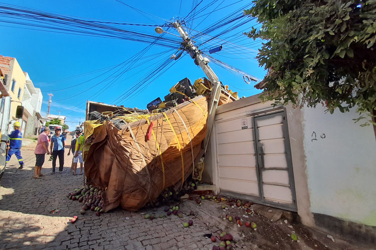 Caminhão carregado com manga tomba e atinge poste e muro de residência em Brumado