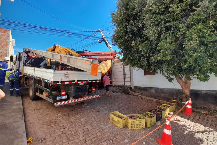 Caminhão carregado com manga tomba e atinge poste e muro de residência em Brumado