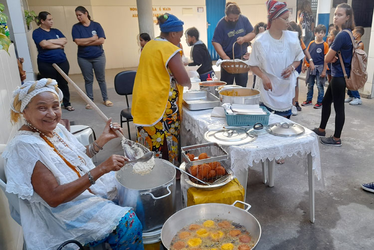 Celebrando o dia de Cosme e Damião, Baiana oferta acarajé para estudantes em Brumado