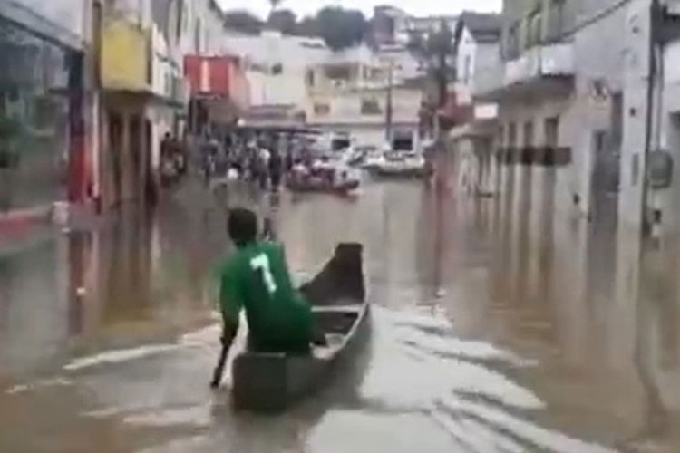 Moradores de Medeiros Neto usam canoas para se deslocarem pelas ruas